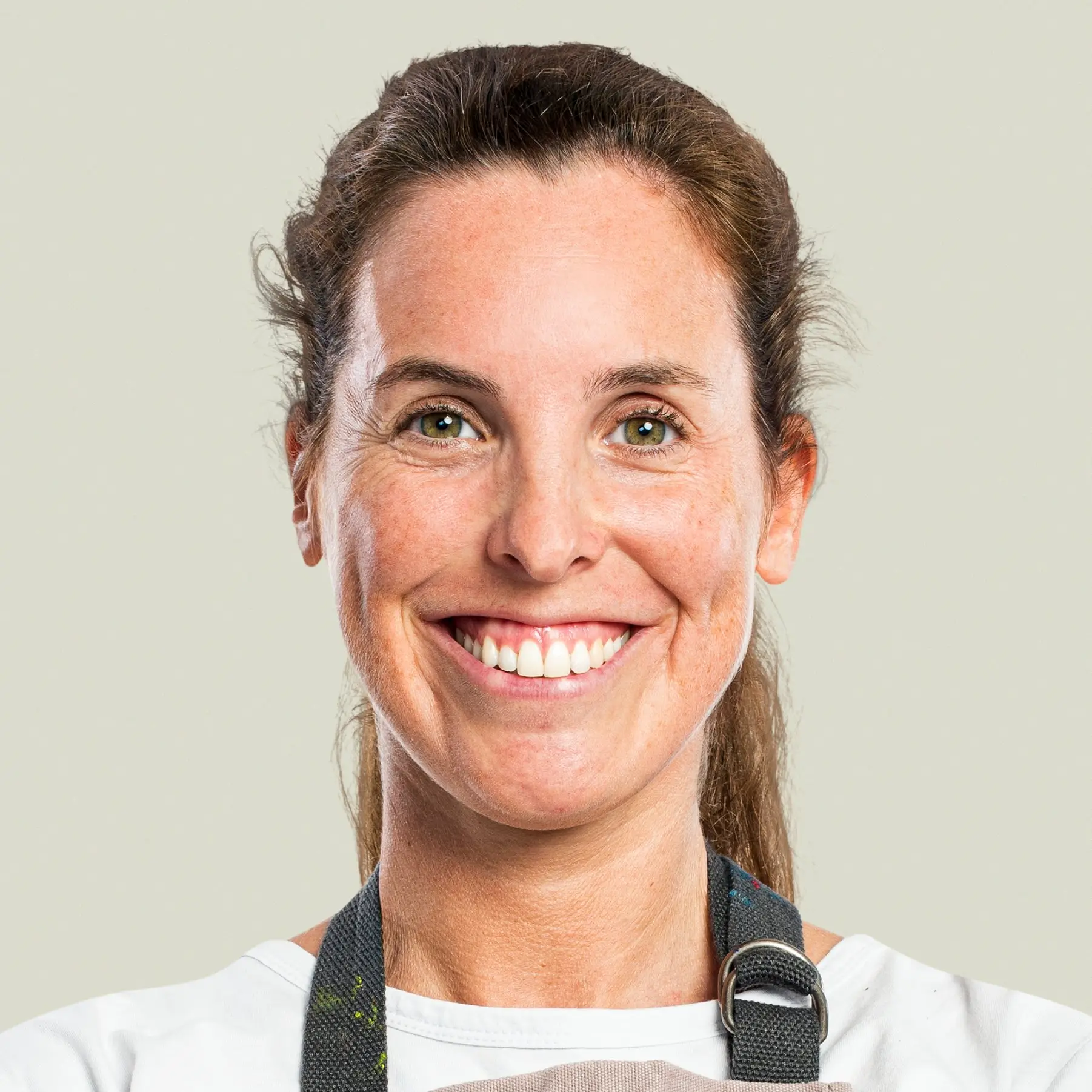 Portrait of Emma Clarke, Pastry Development Assistant at DoughDazzle, smiling in a bright studio setting.