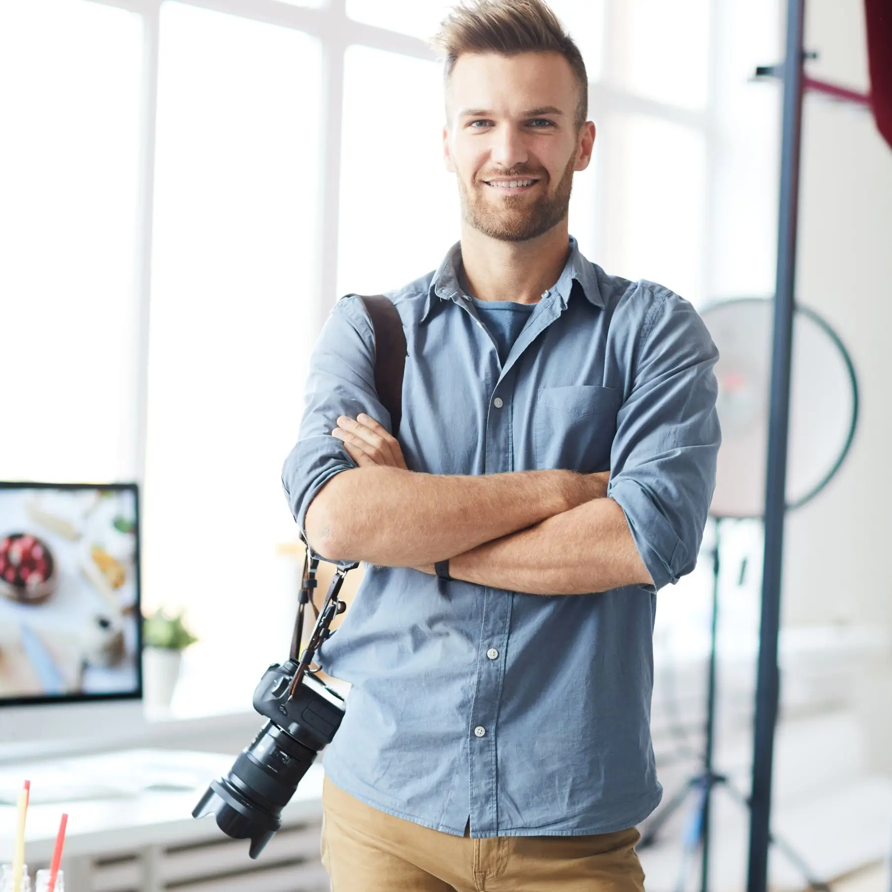 Portrait of Leo Martin, Food Photography & Content Coordinator at DoughDazzle, standing in a bright studio with a camera.