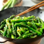 asparagus stir fry with garlic and sauce in wok