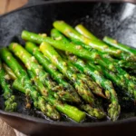 blistered asparagus with crispy charred edges in skillet