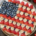4th of July Fruit Pizza topped with strawberries, blueberries, and bananas in a flag design