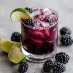blackberry margarita with fresh berries lime and ice in a glass