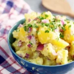 Easy No Mayo Potato Salad with red onions and fresh herbs in a blue bowl