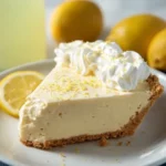 Slice of creamy lemonade pie with whipped topping and lemon zest garnish