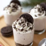 No-Bake Oreo Cheesecake Cups topped with whipped cream and Oreo cookie crumbs