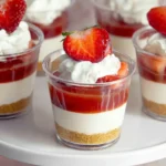 No-Bake Strawberry Cheesecake Cups topped with whipped cream and fresh strawberries