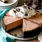 Creamy no-bake chocolate dessert pie topped with whipped cream and chocolate pieces